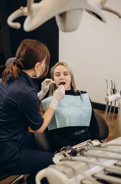 Dentist examining patient's teeth in modern clinic. Cosmetic dentistry